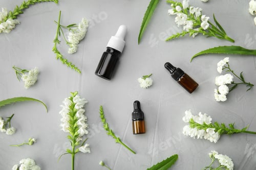 Preview: Flat lay composition with essential oils and flowers on grey background