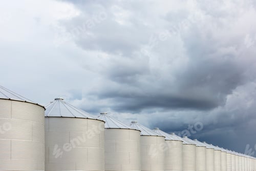 Preview: Rows of grain silos, stormy skies in distance, Saskatchewan, Canada.