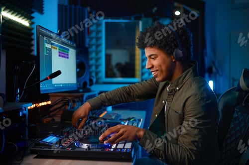 Preview: Young man paying music on sound mixer in radio station