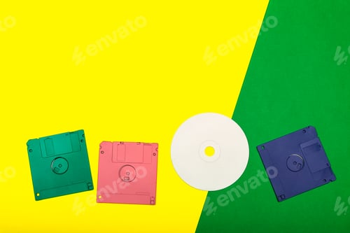 Preview: Vintage technology displayed with colorful floppy disks and a CD on bright background
