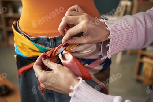 Preview: Caucasian Young Adult Woman Tying Colorful Scarf Around Friends Waist