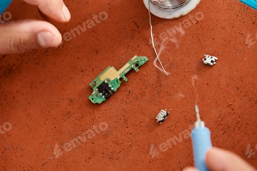 Preview: cropped view of professional repairman with soldering iron near microscheme in private workshop