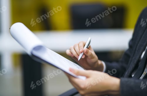 Preview: A man signs a contrac, legal or business agreements. Male hand with pen makes notes.