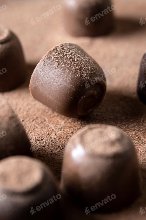 Preview: Chocolate bonbons and cocoa powder background