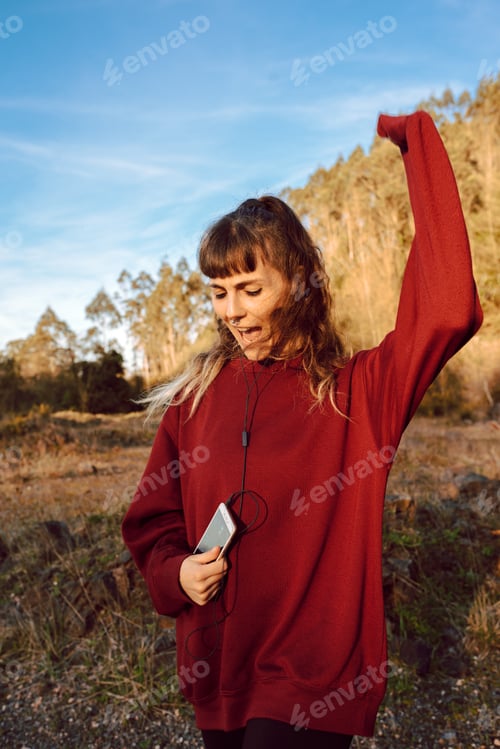 Preview: Young woman with smartphone dancing