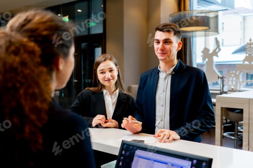 Preview: The receptionist at the counter meets guests with luggage in the hotel business travel hospitality