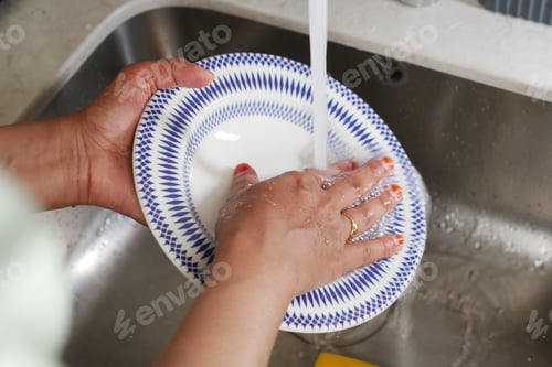 Preview: rear view of woman hand washing a a plate