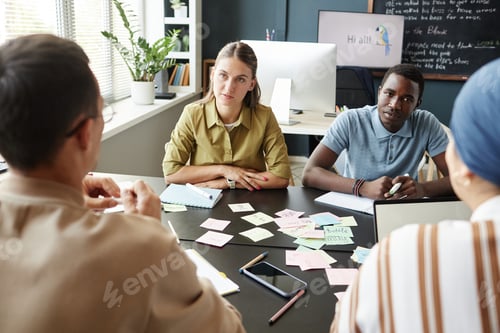 Preview: Woman Sitting at Desk in Group Discussion with Multiethnic Adult Students at Language School