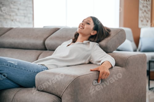 Preview: Trying automatic switches. Woman is visiting bed store. Looking for comfortable sofa