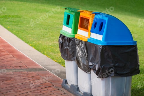 Preview: 3 colorful recycle garbage bins on stone tiles pavement with green lawn in public park area