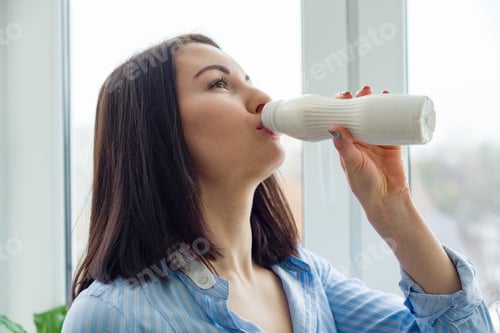 Preview: Young beautiful woman with bottle of milk, yogurt, dairy product