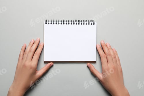 Preview: Female hands and blank notebook on light gray background