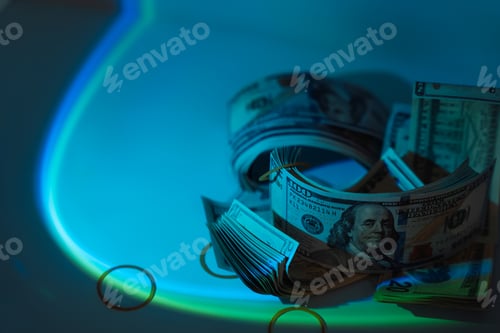 Preview: Stacks of hundred dollar bills under hard blue light