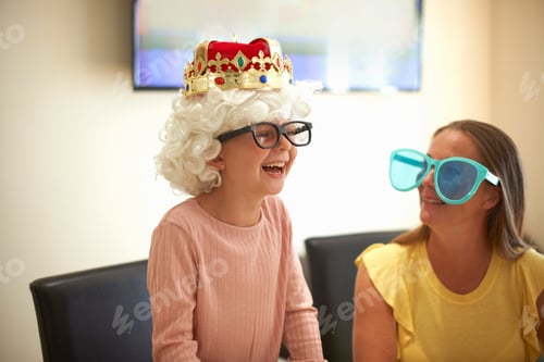 Preview: Mother and daughter playing dress up, wearing funny hats and glasses, laughing