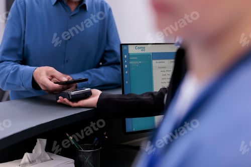 Preview: Close up of elderly patient putting mobile phone on pos paying for health care treatment and
