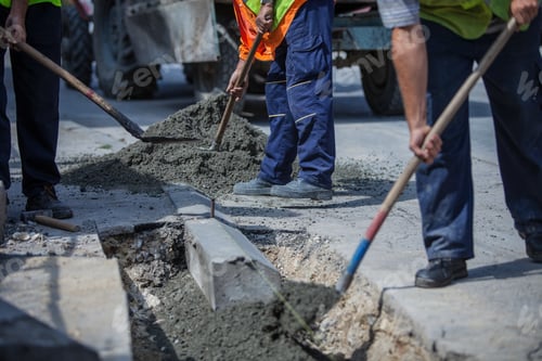Preview: Workers with uniforms filling the hole with cement for installing a sidewalk