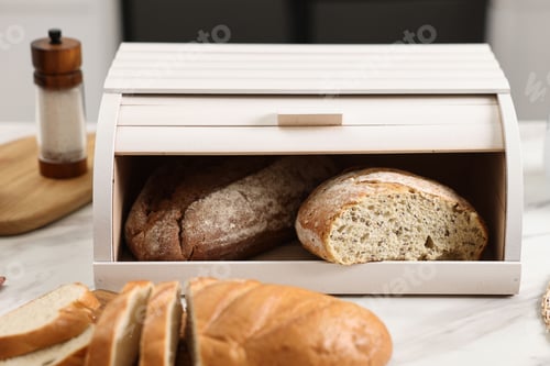 Preview: Wooden bread basket with freshly baked loaves on white marble table in kitchen