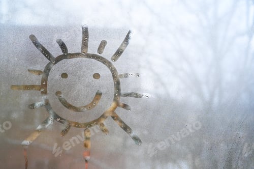 Preview: drawing of cheerful smiling sun on wet glass.