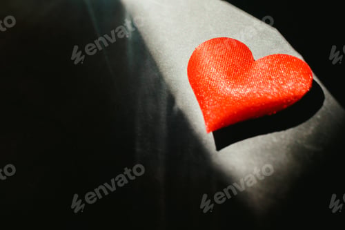 Preview: Red hearts isolated dark background illuminated by a ray of sun to use in the background