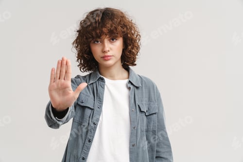 Preview: Ginger young woman looking at camera and showing stop gesture