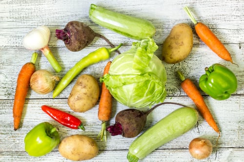 Preview: Close up of various colorful raw vegetables on white wooden background.