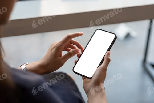 Preview: Close up businesswoman hand holding a smartphone blank white screen at the office. mock up.