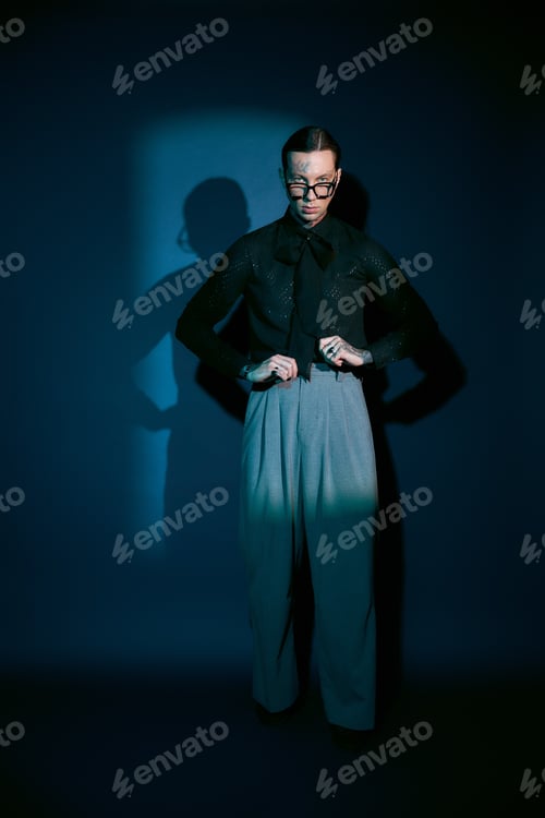 Preview: Handsome young man showcasing modern style in a chic, minimalist setting with dramatic shadows