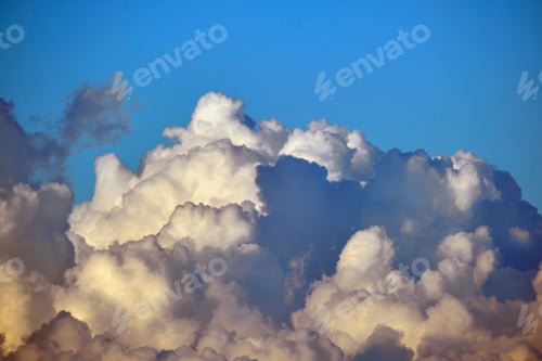 Preview: White fluffy cumulonimbus clouds forming before thunderstorm on summer blue sky.