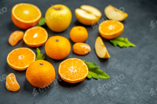 Preview: top view cut apples and oranges mandarines on dark background free place