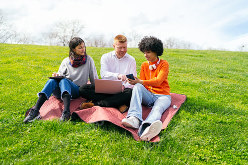 Preview: Students working on a project outdoors using laptop and tablet