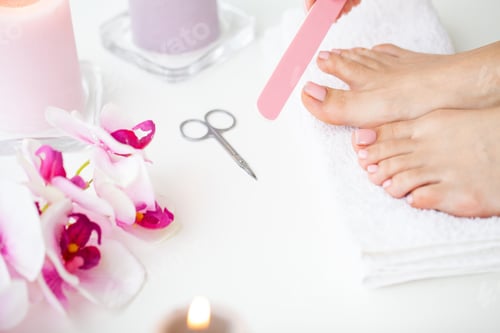 Preview: Cheerful Girl Doing Nails Making Pedicure Sitting In Bed Indoor.