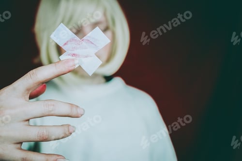 Preview: Artistic portrait of a young woman holding a cross with a kiss print