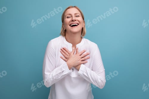 Preview: blond mature woman in a white blouse with a kind heart is ready for hugs