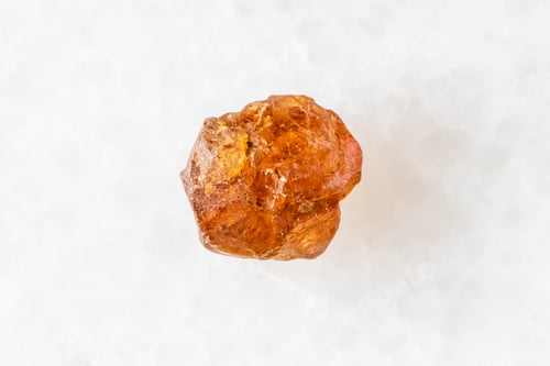 Preview: uncut hessonite grossular crystal on white marble