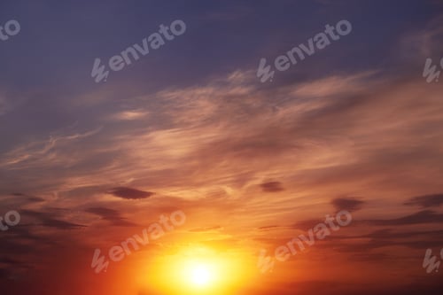 Preview: Beautiful colorful dramatic sky with clouds at sunset. Bright orange setting sun low on the horizon