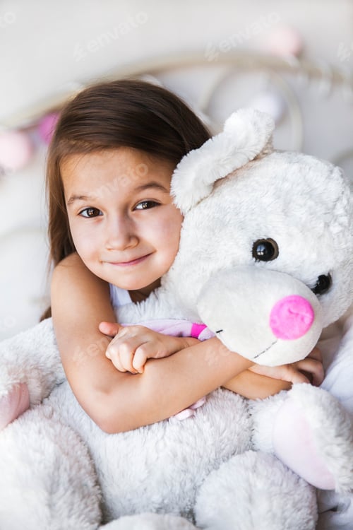 Preview: Little girl with her teddy sitting on the bed. home, comfort, family, relationships, people