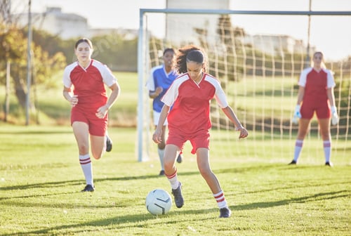 Preview: Female football, sports and team playing match on a field while kicking, tackling and running with
