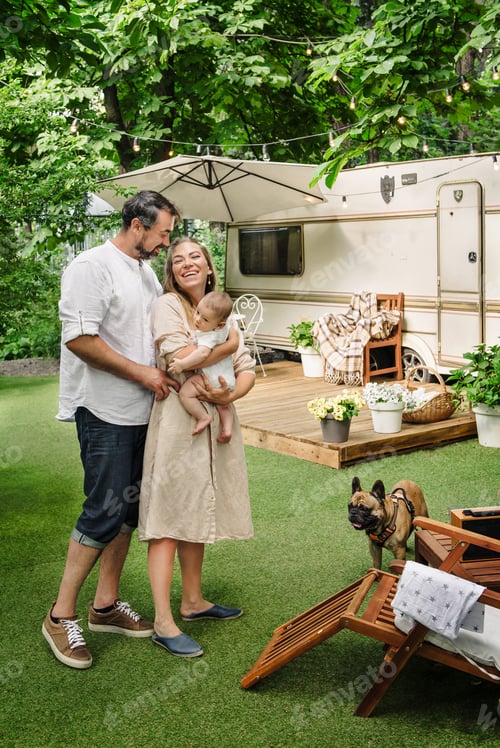 Visualização: Família com bebê e cachorro passando momentos felizes juntos perto do trailer na espreguiçadeira, viajando