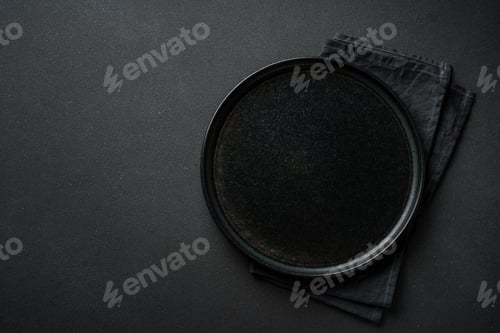 Preview: Black plate at black background. Top view with space for text.