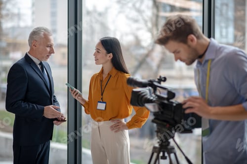 Preview: Male young operator looking busy with his video camera