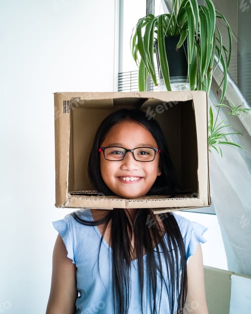 Preview: funny girl head in a cardboard box pretending as a tv presenter.
