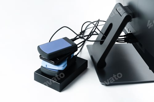 Preview: Multiple external hard drives connected to a monoblock on a white background.Computer with hard