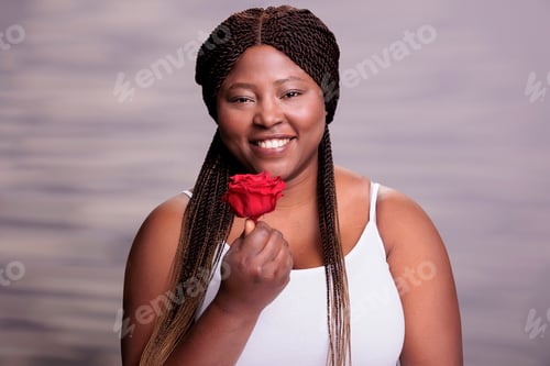 Preview: Beautiful body positive woman giving red rose bud portrait