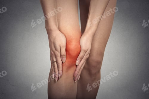 Preview: Closeup Tendon Knee Joint Problems On Woman Leg Indicated With Red Spot Isolated On Gray