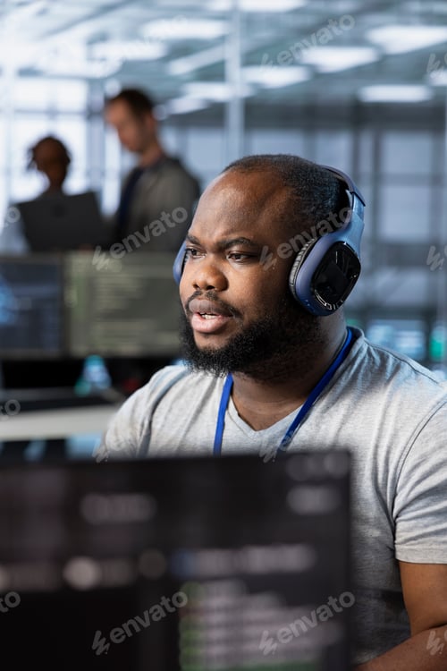 Preview: Engineer in data center listening music, optimizing IT infrastructure