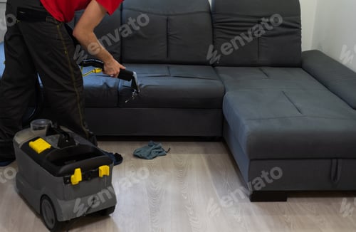 Preview: Man dry cleaner's employee cleaning sofa with professionally extraction method