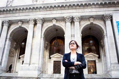 Preview: Confident businesswoman standing against New York Public Library