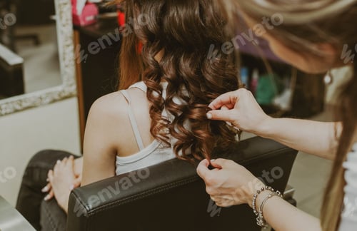 Preview: Portrait of a young girl doing her hair at the hairdresser.