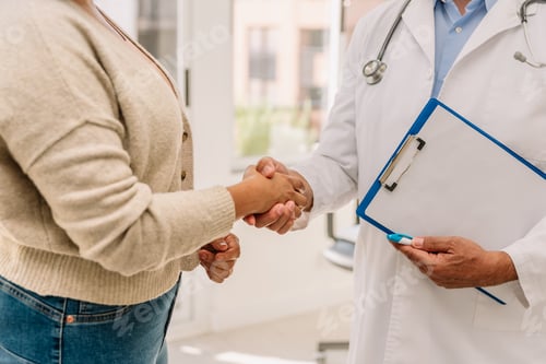 Preview: unrecognizable doctor shakes hands with patient in consulting room