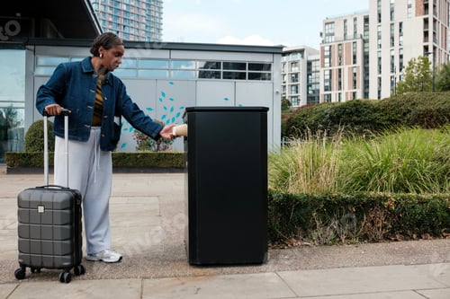 Preview: Traveler throwing garbage in public bin on city street